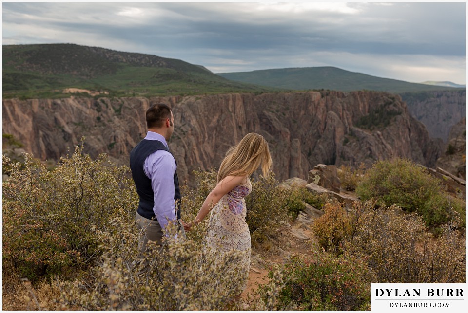 black canyon colorado elopement wedding adventure newlyweds bride and groom walking down to canyon view