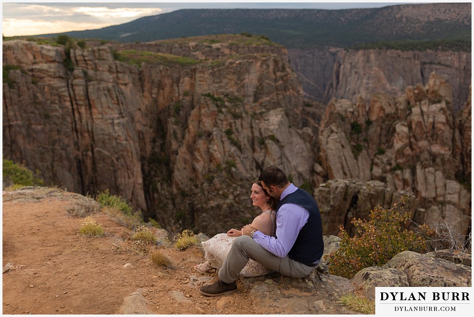 black canyon colorado elopement wedding adventure bride and groom sitting along ledge of canyon