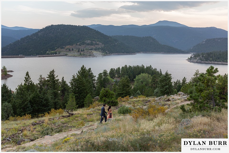 boulder colorado engagement session in the mountains wide view of mountains and couple walking to the lake