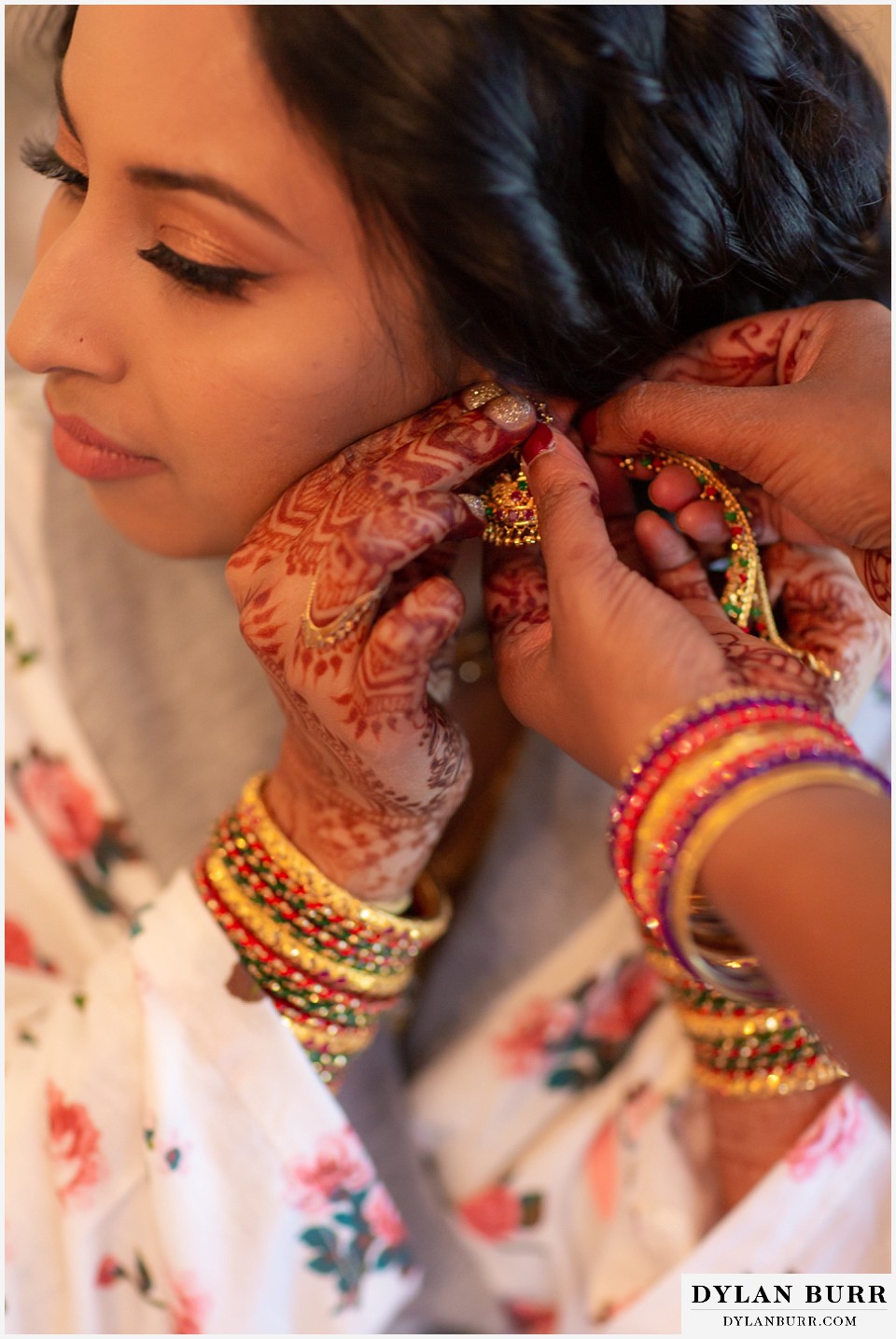 cielo at castle pines wedding colorado mountain wedding close up of henna art on brides hands and putting on earrings