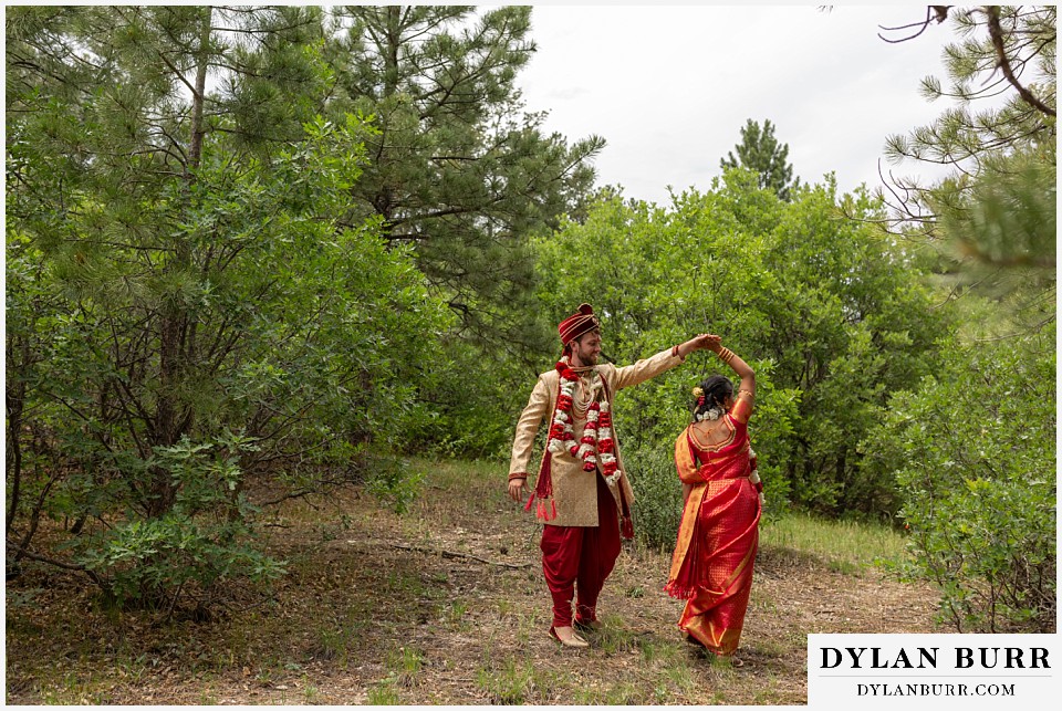 cielo at castle pines wedding colorado mountain wedding hindu bride and groom dancing in a clearing in woods