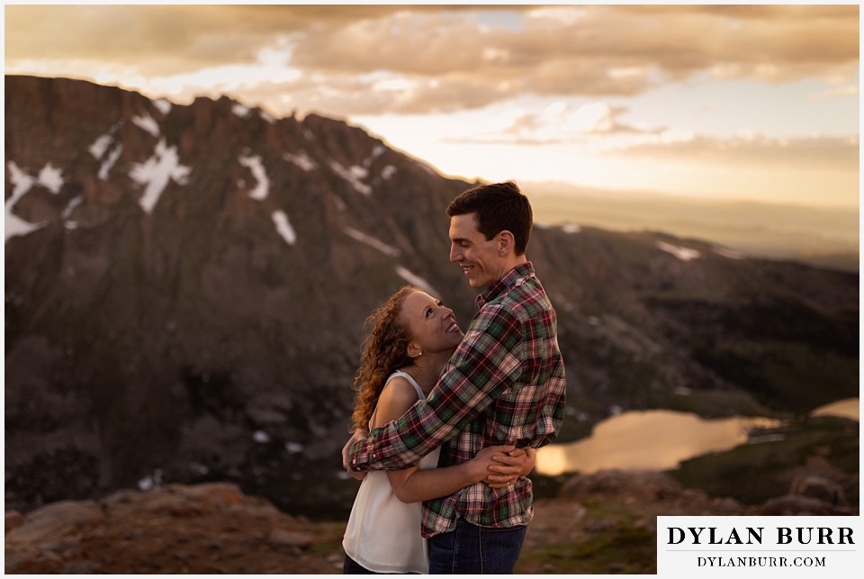 colorado mountain enagagement photo session couple holding each other with snow capped mountains