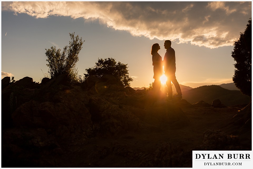 golden colorado mountain enagagement photo session couple standing together with sunset glow between them