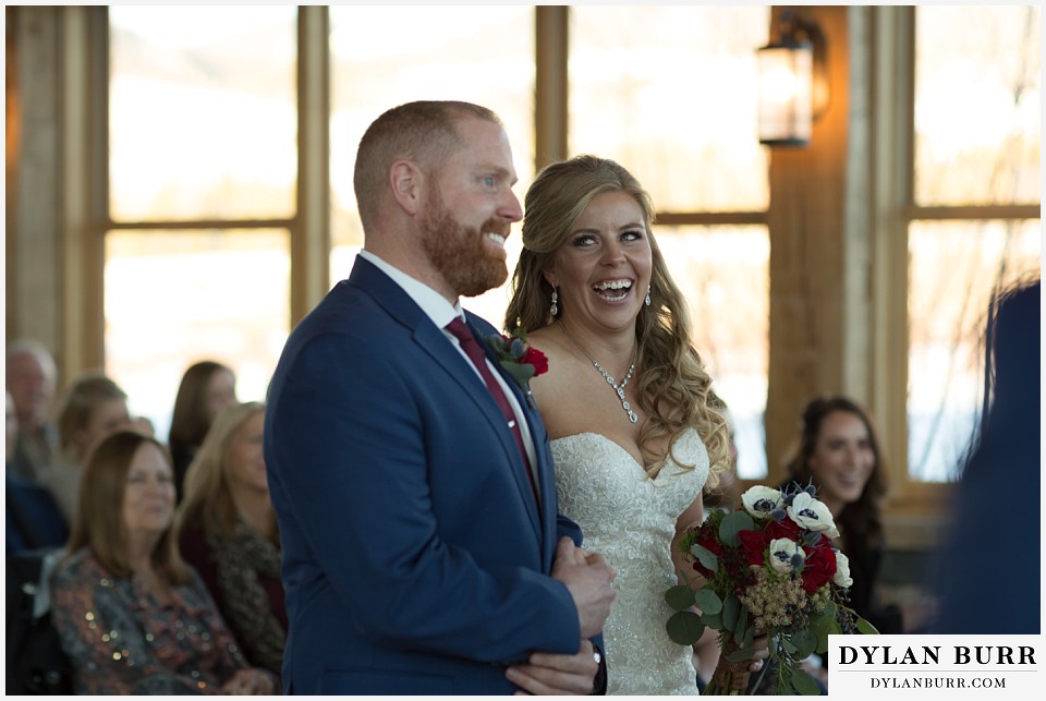 devils thumb ranch wedding in winter  ceremony timber house bride laughing