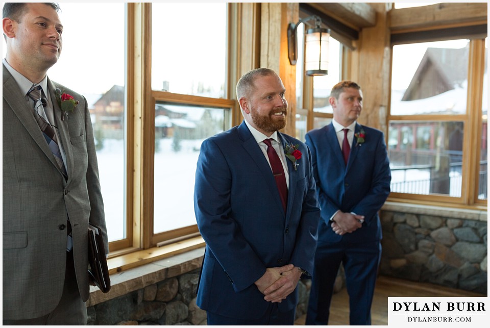 devils thumb ranch wedding in winter ceremony timber house excited groom