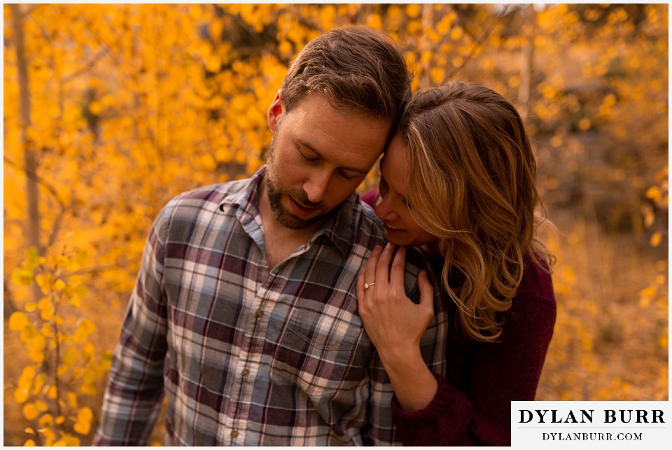 fall engagement photos in colorado shes' whispering something to him