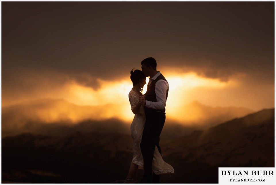 rocky mountain national park grand lake wedding elopement bride and groom dancing on mountaintop at sunset