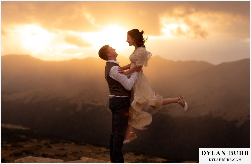 rocky mountain national park grand lake wedding elopement groom lifting up bride in air at sunset