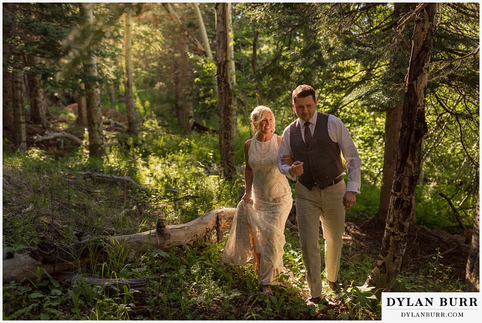 rocky mountain national park wedding elopement bride and groom walking through forest