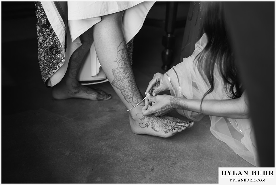 spruce mountain ranch wedding indian wedding bride's henna on feet putting on ankle bracelet