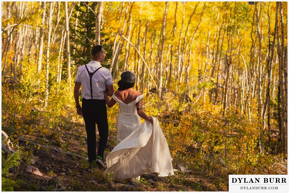winter park mountain lodge wedding colorado bride and groom walking together in aspen trees