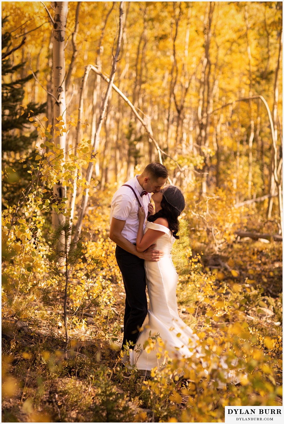 winter park mountain lodge wedding colorado bride and groom sharing a kiss surrounded by yellow aspen leaves
