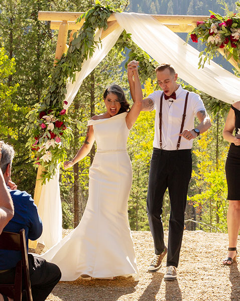 newlywed couple walking down aisle together cheering