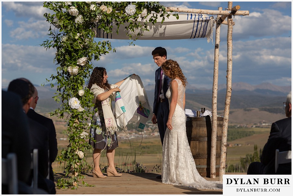 bride and groom wrapping up in jewish tallit