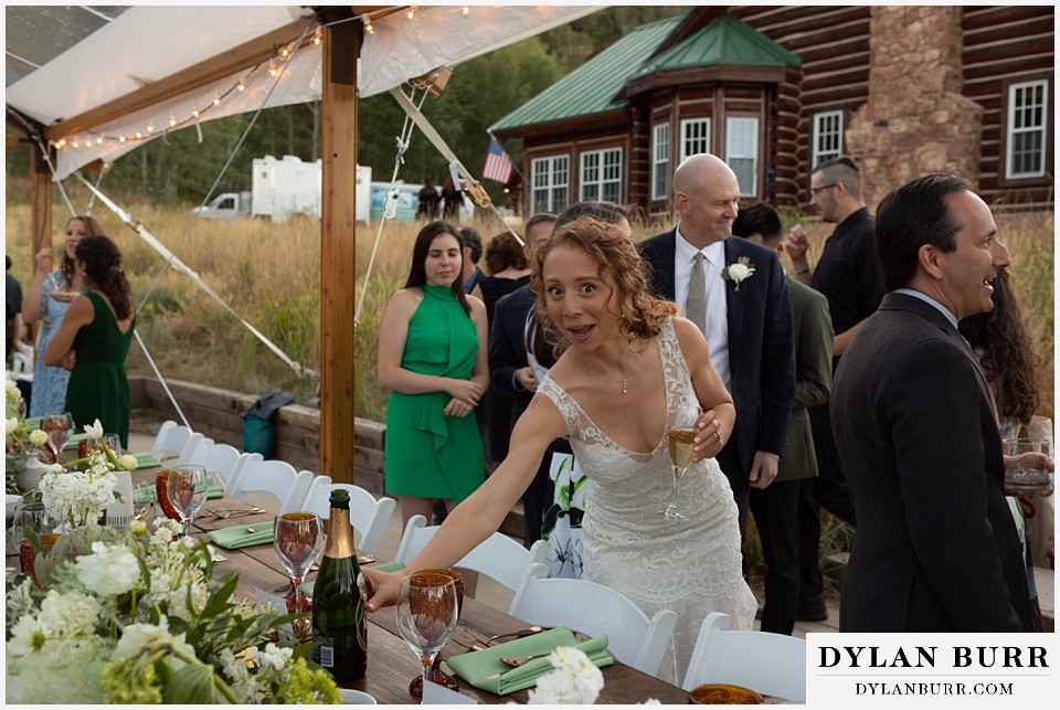 funny bride grabbing more champagne Antler Basin Ranch wedding