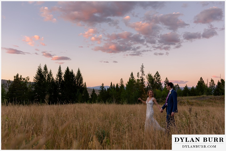 bride and groom walking together at sunset alpenglow Antler Basin Ranch wedding
