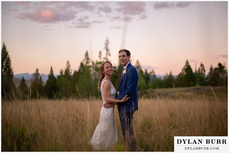 gorgeous bride and groom in field at Antler Basin Ranch wedding during alpenglow sunset