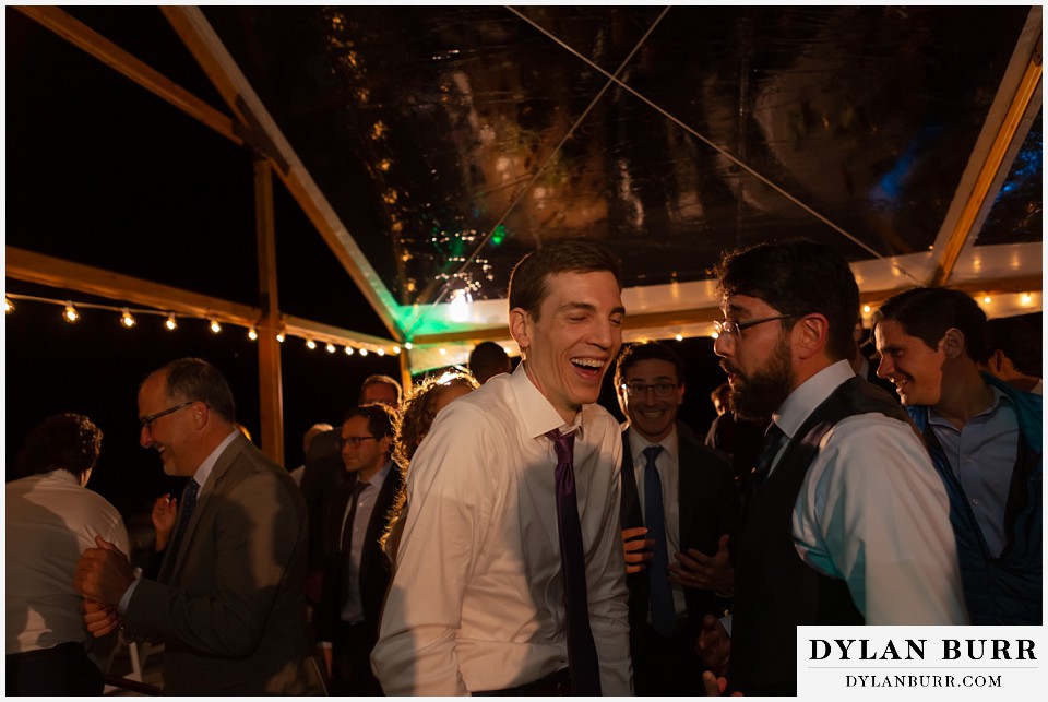 groom laughing with a friend during reception antler basin ranch wedding