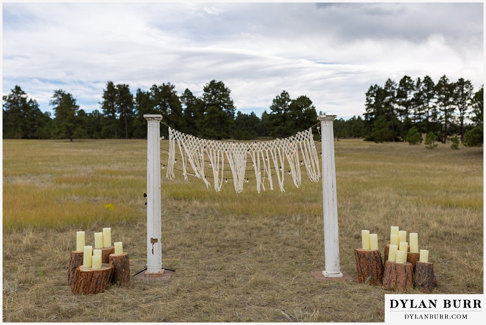 boho backyard colorado wedding columns with string lights and macrame backdrop