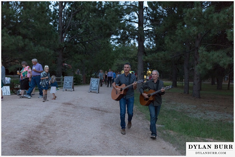 boho backyard colorado wedding guitarists moving down to ceremony site