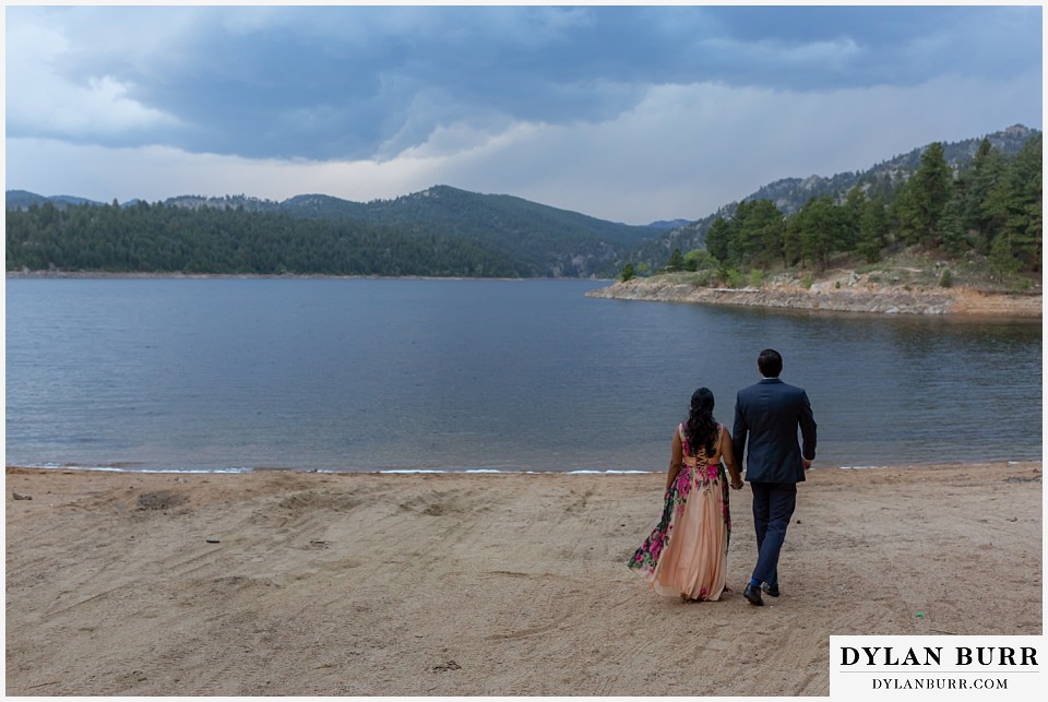 boulder colorado engagement session in the mountains couple walking out to the lakeshore