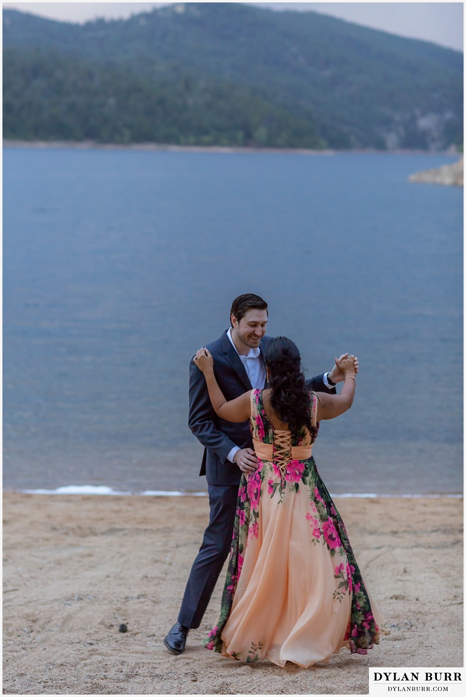 boulder colorado engagement session in the mountains couple dancing together alongside the lake