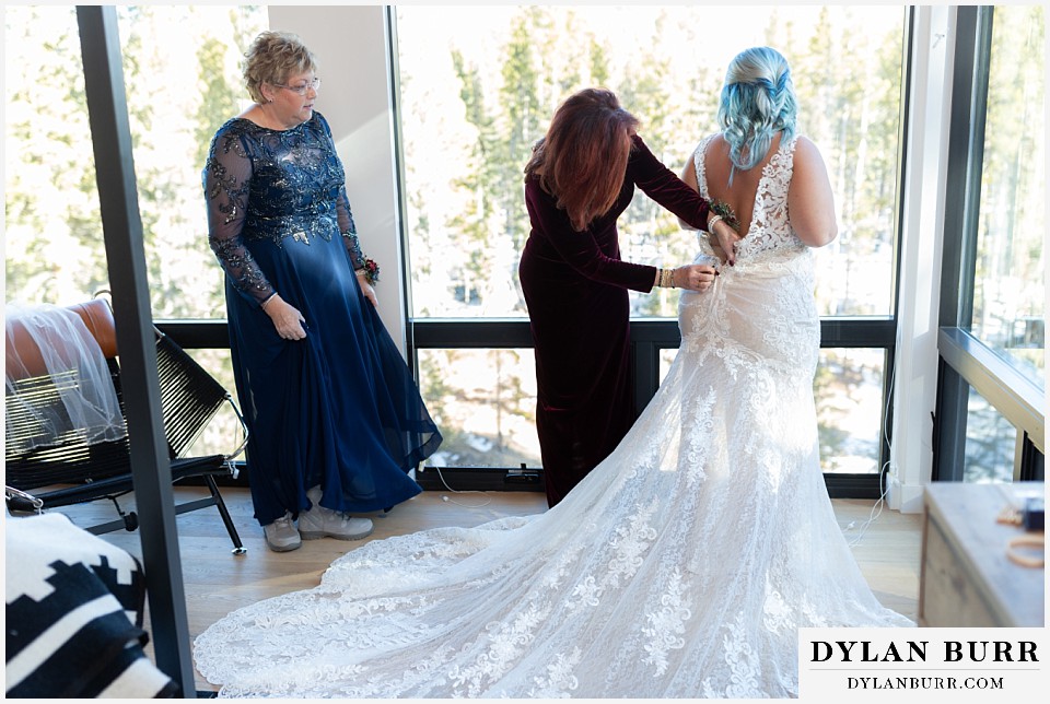 bride getting ready with mom in front of large windows in an airbnb home