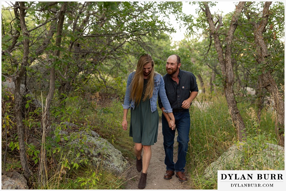 castlewood canyon engagement photos couple walking through oak trees on a hike