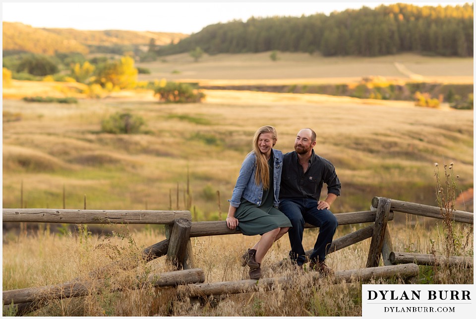 castlewood canyon engagement photos couple sitting together on fence