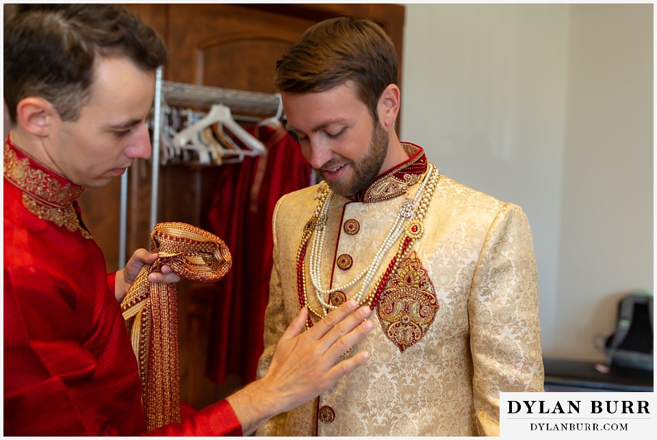 cielo at castle pines wedding colorado mountain wedding groom putting on robe and jewelry