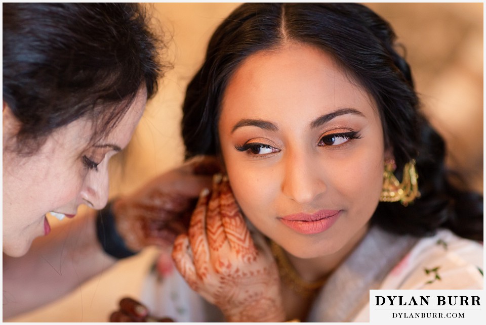 cielo at castle pines wedding colorado mountain wedding close up of bride putting on earrings