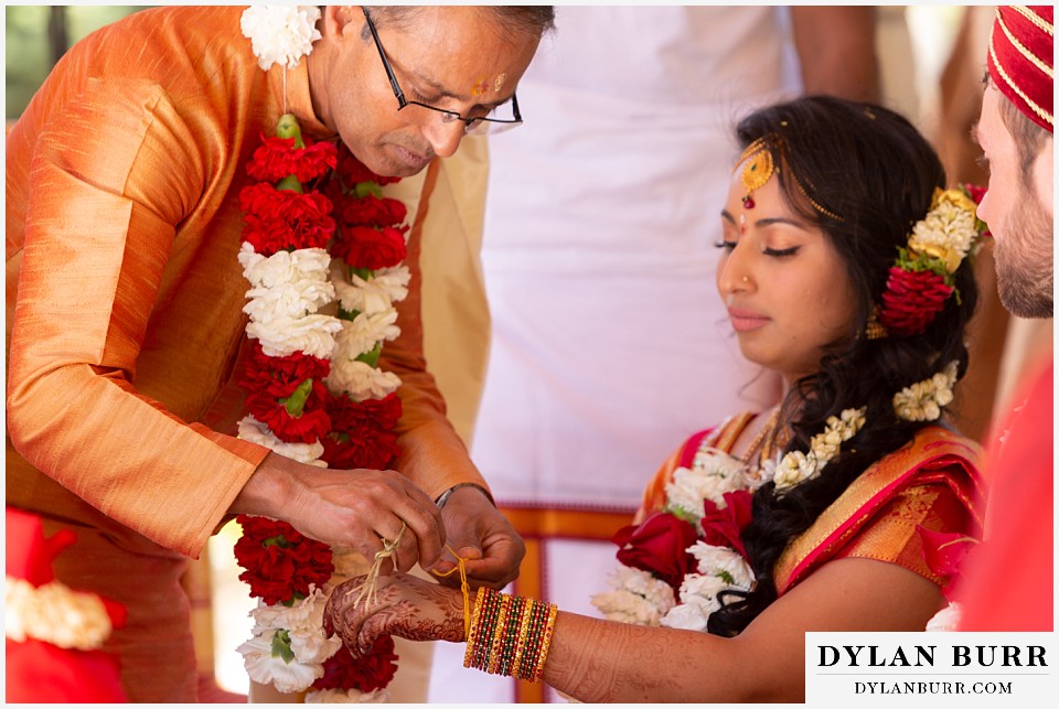 cielo at castle pines wedding colorado mountain wedding brides father tying string on daughter hindu wedding