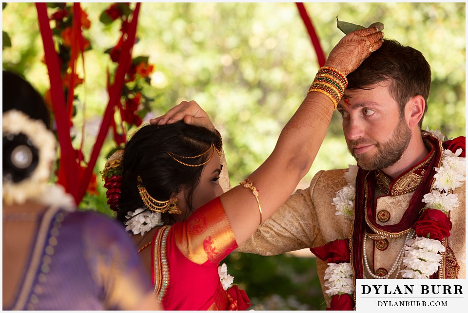 cielo at castle pines wedding colorado mountain wedding bride and groom placing leaves on each other hindu ceremony