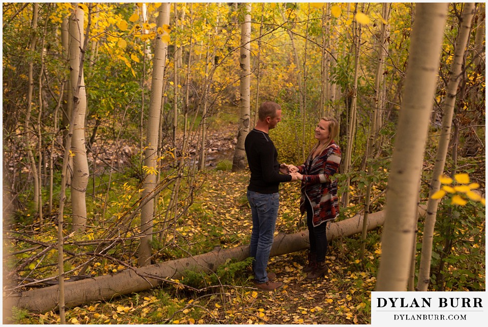 engagement photos in colorado couple standing in forest