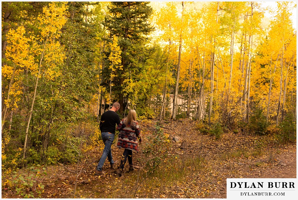 engagement photos in colorado couple walking in to aspen tree forest