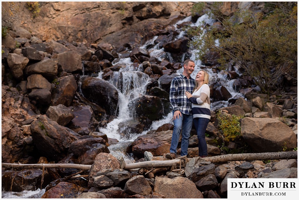 engagement photos in colorado couplle laughing by waterfall