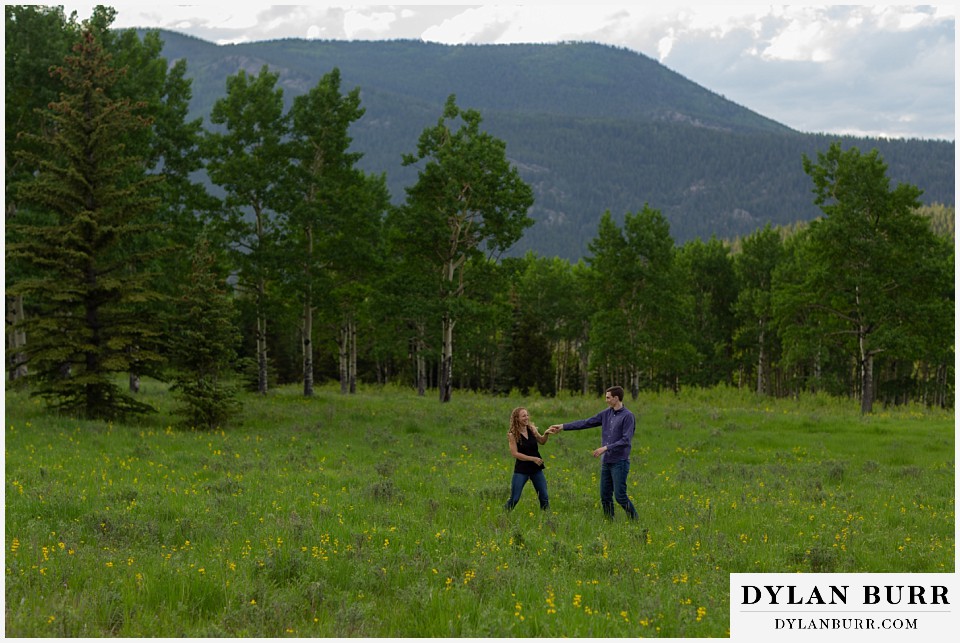 colorado mountain enagagement photo session dancing in wildflower meadow