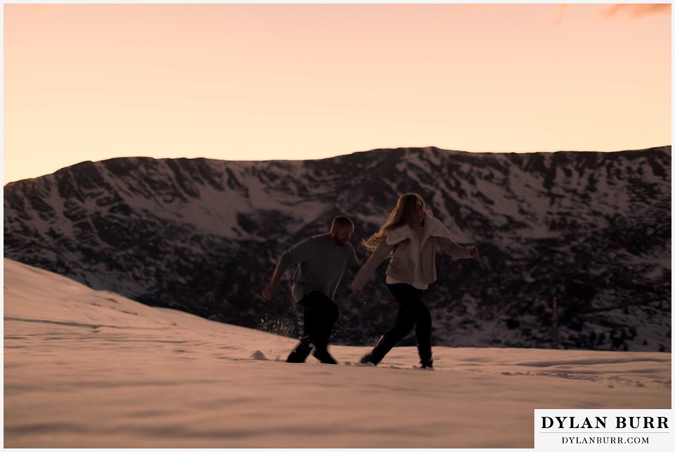 colorado mountain engagement session running in snow at sunset