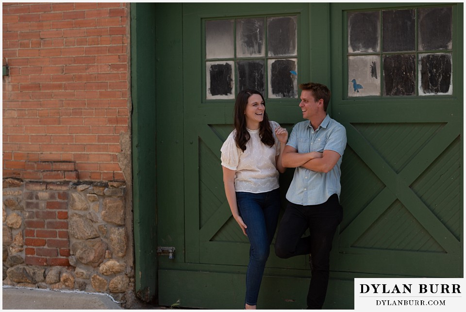 colorado mountain engagement photos colorado wedding photographer dylan burr couple laughing together in front of large green door