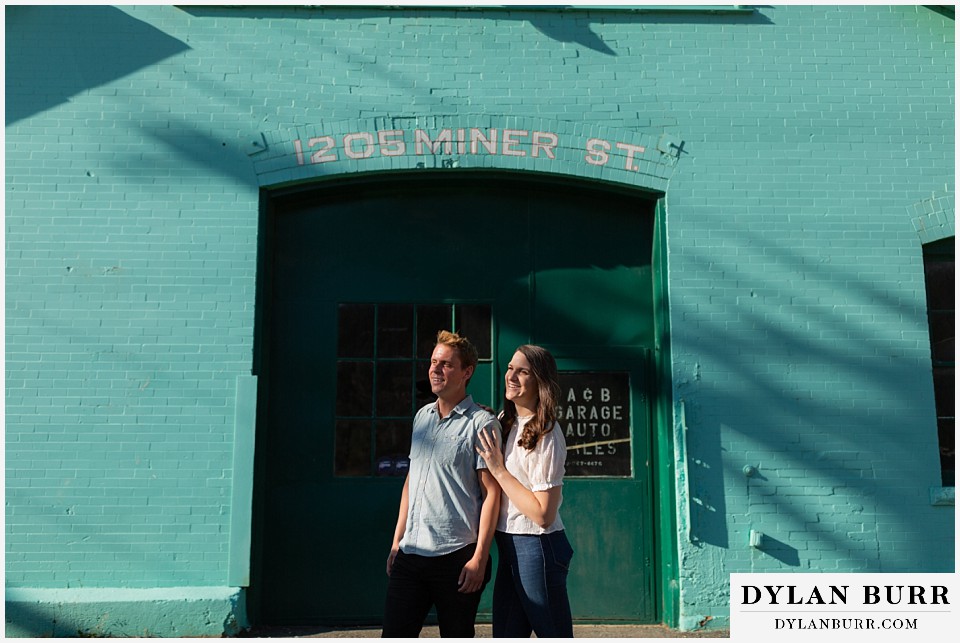 colorado mountain engagement photos colorado wedding photographer dylan burr couple standing together taking in some sun in front of old garage