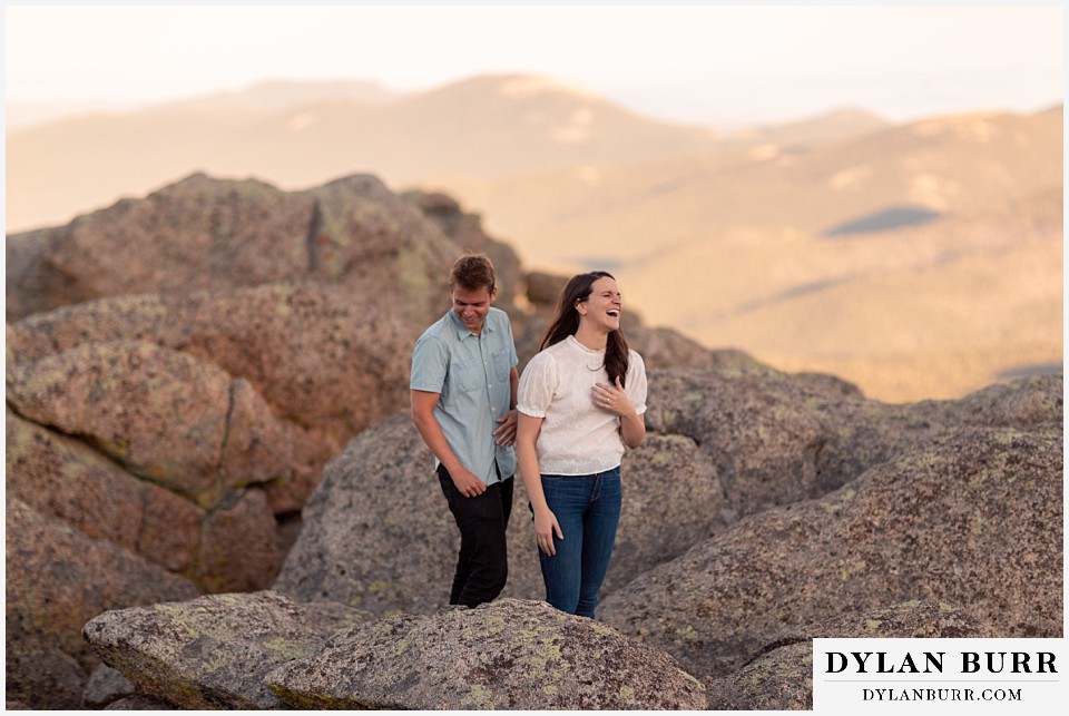 colorado mountain engagement photos colorado wedding photographer dylan burr couple on top of rocks finding sheep poop and laughing