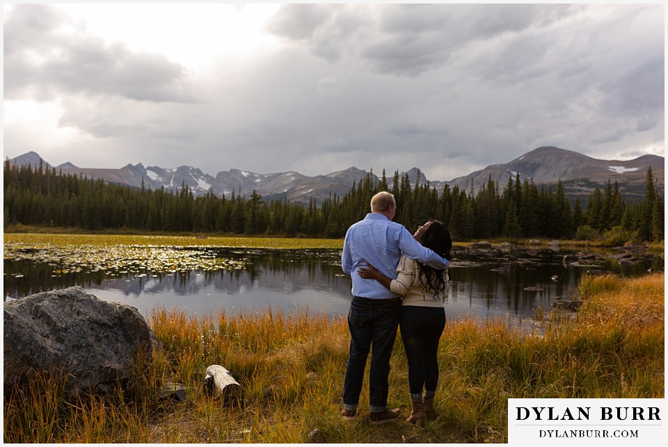 colorado mountain engagement photos couple at mountain lake couple at lake with lily pads and snow capped mountains