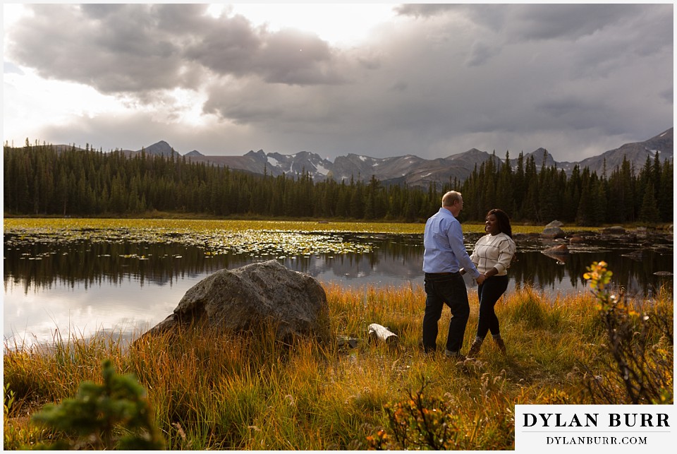 colorado mountain engagement photos couple dancing by lake