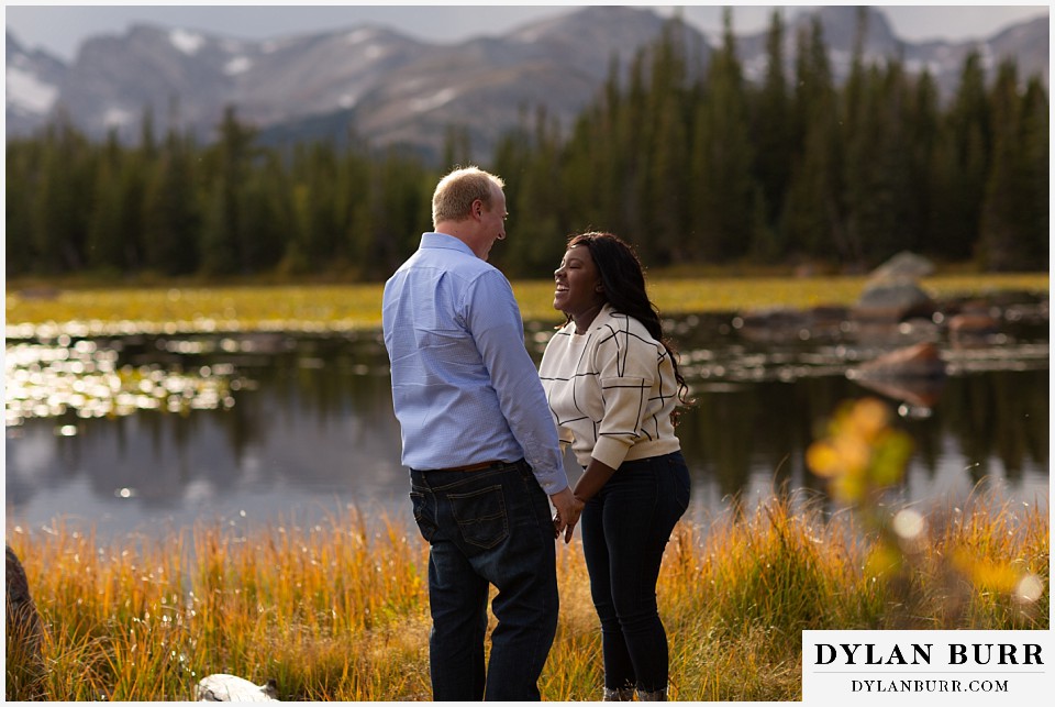 colorado mountain engagement photos couple laughing together at lakeside