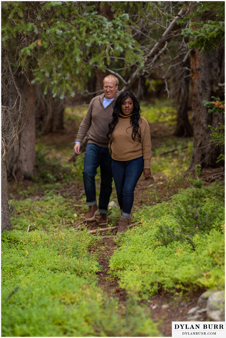 colorado mountain engagement photos bride leading groom down forest trail