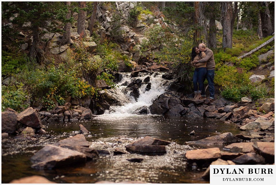 colorado mountain engagement photos couple snuggling in close by waterfall