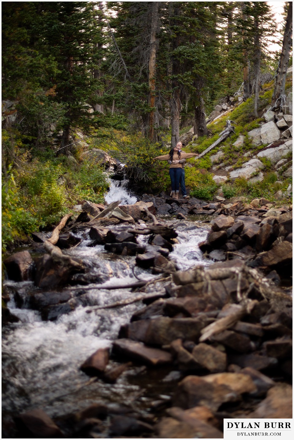 colorado mountain engagement photos bride and groom being funny by riverside