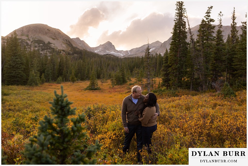 colorado mountain engagement photos couple laughing together in fall meadow