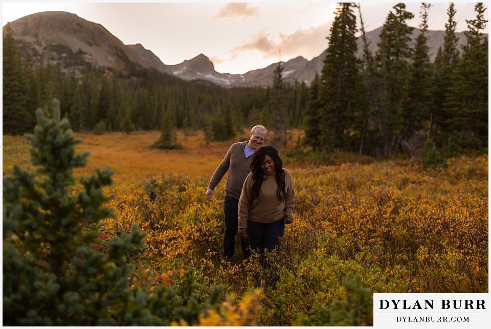 colorado mountain engagement photos couple walking out of meadow