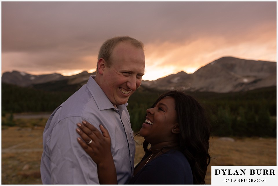 colorado mountain engagement photos couple laughing together at sunset